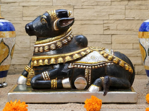 This Black Marble Nandi, adorned in golden accents and intri